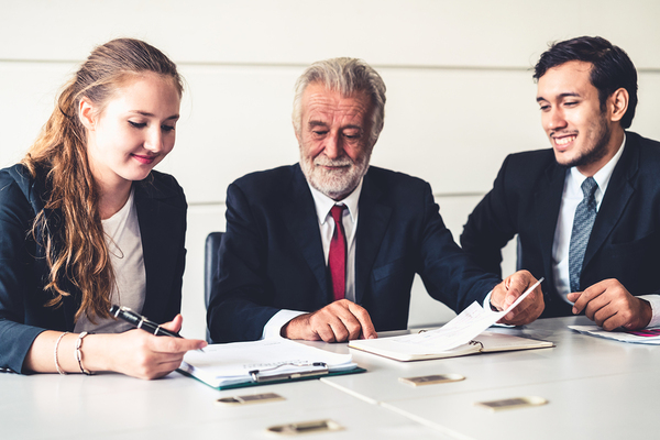 Three coworkers looking at documents together.